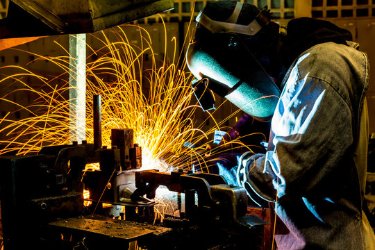 Industrial worker welding in factory
