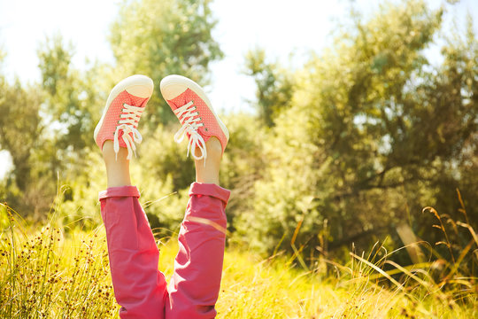 Female legs in colorful sneakers outdoors