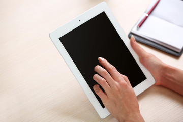 Woman using digital tablet on workplace close up