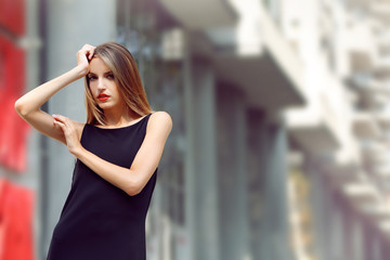 Beautiful young girl posing on city street