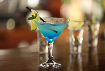 Glasses of cocktails on bar background
