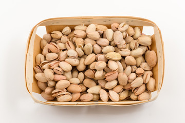 wooden container is filled with pistachios on a white background