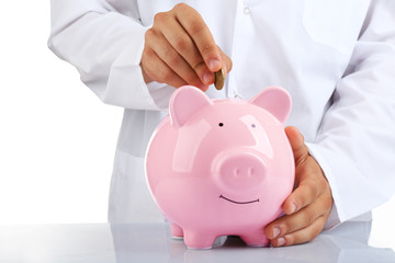 Man put coin into a piggy-bank