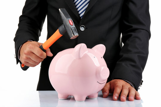 Man with a hammer going to break the piggy bank, close up