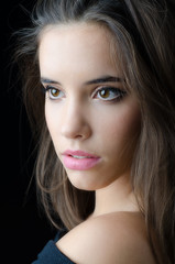 Fototapeta premium Portrait of the beautiful brunette girl isolated on black background.
