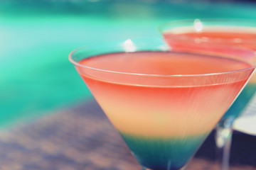 Cocktails on swimming pool background