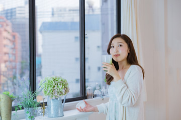 スムージーを飲むパジャマ姿の女性
