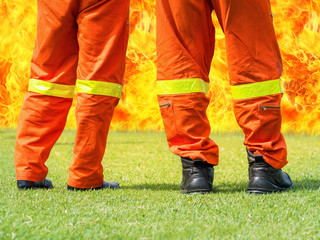 Fototapeta premium firemen standing in front of a big flame