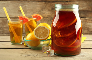 Iced tea with lemon and grapefruit on wooden background