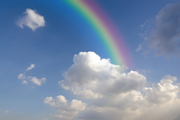 Clear blue sky with white cloud and rainbow