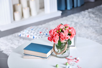 Beautiful rose in vase on table in room