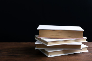 Books on the table on black background