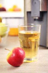 Juicer and apple juice on kitchen table