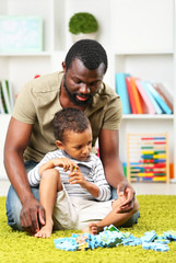 Obraz premium Father and son paying in the children room