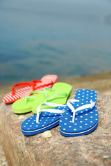 Bright flip-flops on stone, nature background