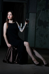 Young woman with glass of red wine in the room