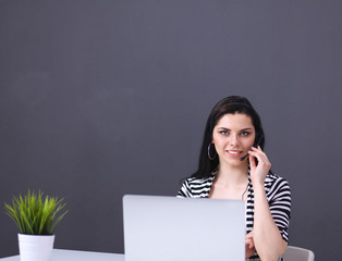 Beautiful business woman working at her desk with headset and