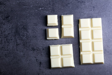 White chocolate pieces on gray background