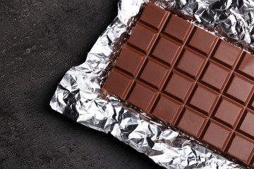 Chocolate bar in foil  on gray background