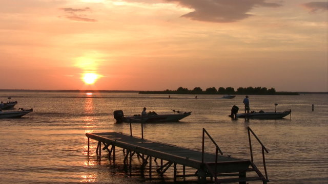 sunset fishing boats around pier water ski Texas HD