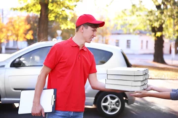 Papier Peint photo Lavable Pizzeria Pizza delivery boy holding boxes with pizza near car