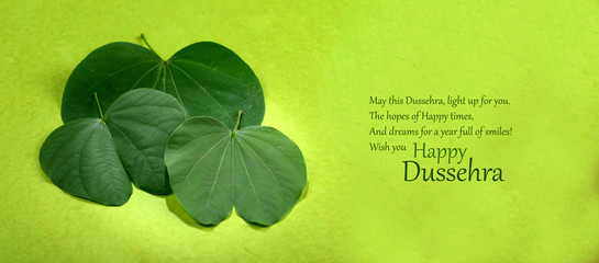 Indian Festival Dussehra, showing golden leaf on green background. Greeting card. © Dipak Shelare