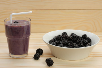 Fototapeta na wymiar Smoothie from blackberries in a glass and blackberries on wood