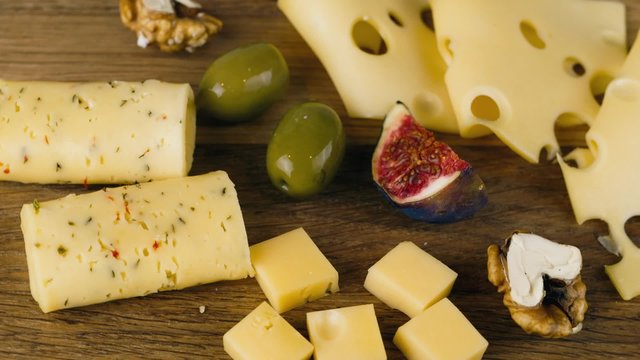 A set of different cheeses with figs, turns to the camera