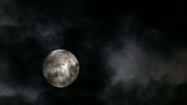 timelapse with full moon moving between clouds
