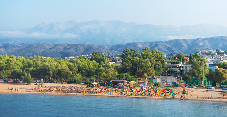 Fototapeta premium Tropical beach with deckchairs, umbrellas and people.