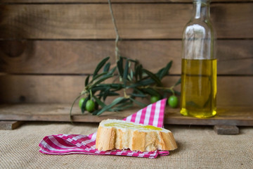 Olive oil with olives on wooden board
