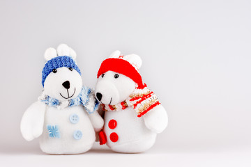 Pair of cute plush rabbits in warm clothes. Sweet couple of toys in scarfs and caps. Christmas background with empty space for text.