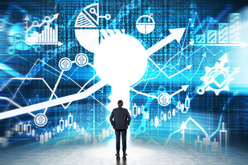 A keyhole in the wall with drawn financial charts. A businessman dressed in formal clothes is...