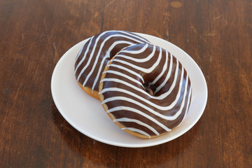 donut with chocolate-colored zebra on a brown background. top view. space for inscriptions.