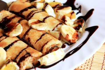 Pancakes stuffed with semolina, bananas and oranges drenched