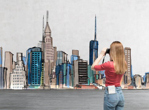 Young beautiful lady in casual clothes is taking a pictures of the drawn New York. A concept of modern tourism.