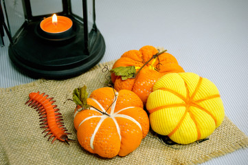 Three little hand-sewn pumpkin with a candle