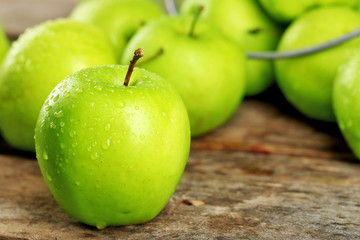 Ripe green apples on wooden table close up