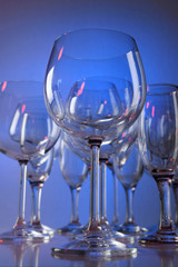 Empty wine glasses on color background