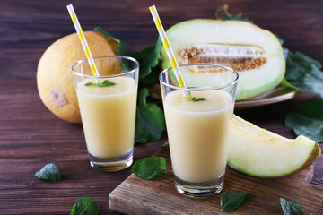 Glasses of melon cocktail on wooden background