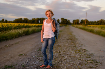 Attractive blond woman on a rural farm road