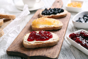 Fresh toast with butter and different jams on table close up