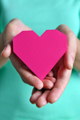 Obraz premium Closeup of plastic puzzle heart in female hands