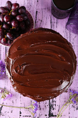 tasty chocolate pie with sweet grape and glass of tea on wooden background