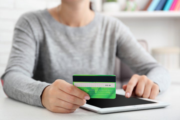 Concept for Internet shopping: hands with digital tablet and credit card