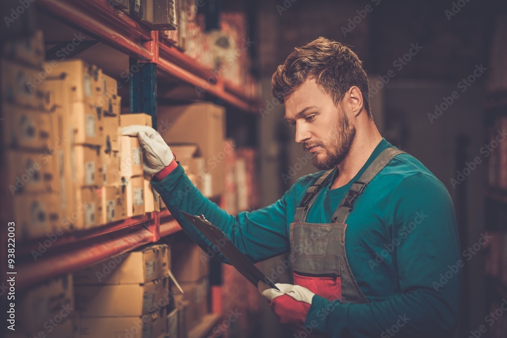 Wall mural worker on a automotive spare parts warehouse