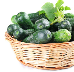 Wicker basket with cucumbers isolated on white