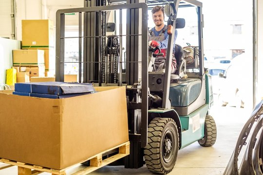Man driving forklift truck on a warehouse