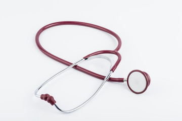 Red stethoscope medical equipment on white background