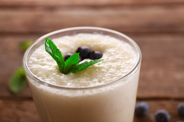 Fresh yogurt with mint and blueberry on wooden background